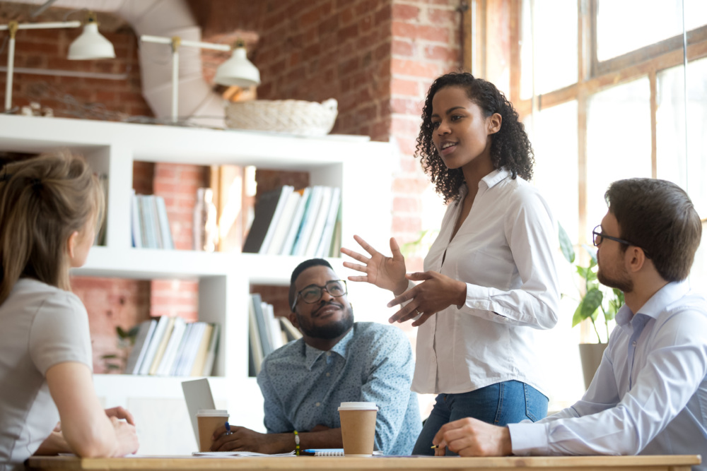 Ambitious female employee speaking at meeting